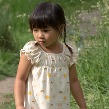 Load image into Gallery viewer,       Little-Green-Radicals-Cream-Pocket-Playdays-Dress-With-Sunshine-And-Rainbow-Print-Kid-Closeup
